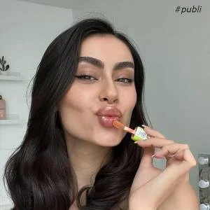 Belonger com gloss da Belong Be nas mãos fazendo biquinho