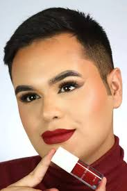 Belonger com make de olhos marcados segurando batom vermelho da Belong Be