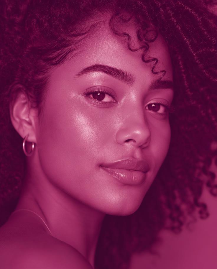 Belonger de pele morena e cachos naturais em luz magenta